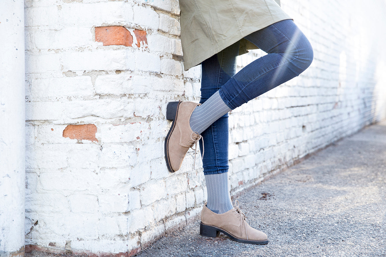 standing against a wall in Rejuva herringbone compression socks