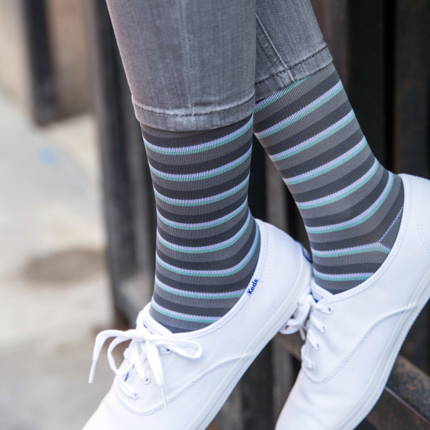 woman feet dangling in Rejuva striped compression socks (15-20 mmHg)